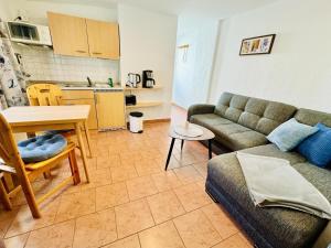 a living room with a couch and a table and a kitchen at Appartement Schwalbenflug in Warnemünde