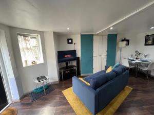 a living room with a blue couch and a table at Exclusive Apartment - close to centre, contactless entry & free parking in Leeds