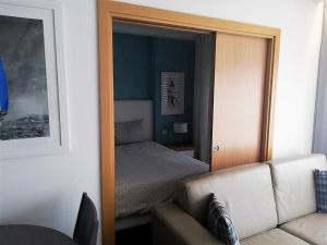 a mirror reflecting a bedroom with a bed and a couch at Apartamentos Turisticos da Nazare in Nazaré