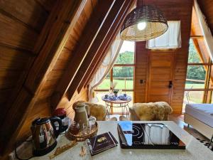 ein Wohnzimmer mit einem Tisch und einem großen Fenster in der Unterkunft Sítio Família Cherba - Cabana do Lago in Videira