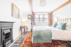 een slaapkamer met een bed en een open haard bij Manor Farm House in Kilmington