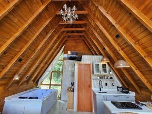 uma cozinha com um grande tecto de madeira com um lustre em Sítio Família Cherba - Cabana do Lago em Videira