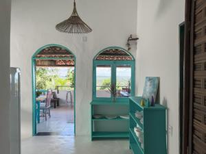 um quarto com duas janelas arqueadas e um armário azul em Vila Rita Hostel Arraial d'Ajuda em Arraial d'Ajuda