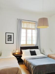 een slaapkamer met 2 bedden en een raam bij Eden Hotel in Haifa