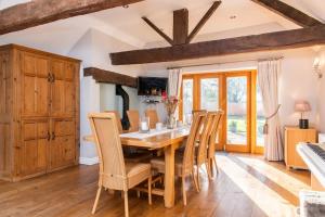 a dining room with a wooden table and chairs at Bank Farm House - Stunning House & Gardens in Shenstone