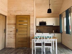 雅洛斯瓦別茲的住宿－Single-story holiday cottages, Jaros awiec，厨房配有白色的桌椅