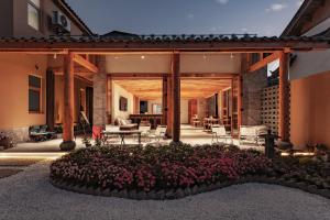 een huis met een terras met een tuin met bloemen bij Humble abode of happiness - Mountain View Wabi-sabi Lodge in Lijiang