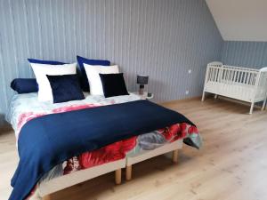 um quarto com uma cama com almofadas azuis e brancas em Le gîte d' Alice em La Chapelle-Saint-Martin-en-Plaine