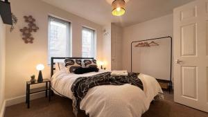 a bedroom with a bed with a black and white comforter at Apartment Shoreditch Bricklane in London