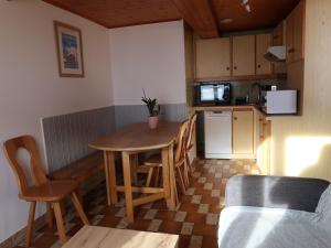 Il comprend une petite cuisine avec une table et des chaises en bois. dans l'établissement LACHAT appartement en chalet typique, au Grand-Bornand