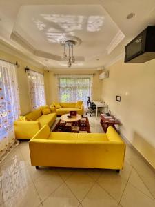 a living room with a yellow couch and a table at Burka Serene Home in Arusha