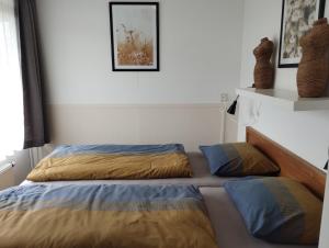 a bedroom with two beds and a picture on the wall at DUINZICHT 8 Bed by the Sea in Westkapelle
