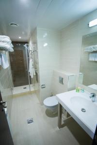 een badkamer met een toilet, een wastafel en een douche bij Iskra Hotel in Chimki