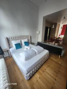 1 dormitorio con 1 cama blanca grande con almohadas azules en Brussels 1904 en Bruselas