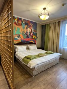 a bedroom with a large bed and a painting on the wall at G Empire in Astana