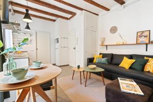 ein Wohnzimmer mit einem Sofa und einem Tisch in der Unterkunft Lodging Apartments Almirall Beach 41 in Barcelona