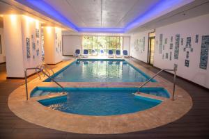 a swimming pool in a large room with a large window at Alejandro 1º Hotel in Salta