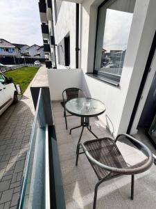 a patio with a table and chairs on a balcony at FLH - Robella Apartment in Sibiu