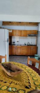 eine Küche mit einem Tisch und einem weißen Kühlschrank in der Unterkunft Cabañas Refugio Verde in El Soberbio