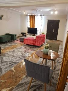 a living room with a red couch and a table at Nana Adu Guest House in Koforidua