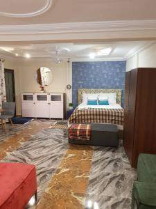 Schlafzimmer mit einem Bett mit blauer Wand in der Unterkunft Nana Adu Guest House in Koforidua