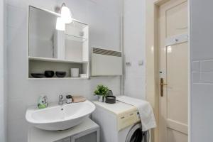 a white bathroom with a sink and a washing machine at S3 Sörház Apartment in Budapest