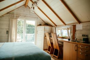 a bedroom with a bed and a desk in a room at L'Escale Zen - Tiny House (Jacuzzi/Sauna) in Theux