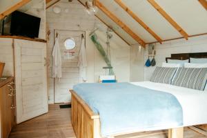 um quarto com uma cama e uma televisão num quarto em L'Escale Zen - Tiny House (Jacuzzi/Sauna) em Theux