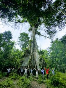 a group of people standing in front of a tree at Bromelia Flower Lodge Iquitos in Iquitos