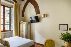 een kamer met een koelkast, een tafel en een raam bij Residenza Della Signoria in Florence