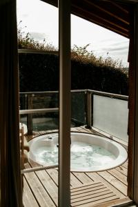 a jacuzzi tub sitting on top of a deck at L'Escale Zen - Tiny House (Jacuzzi/Sauna) in Theux