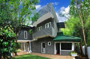 a large house with a green roof at Linwood Bungalow in Kandy