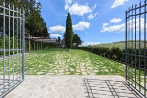 otwarta brama do ogrodu z drzewem w obiekcie Villa Conca d'Oro by Mmega w Greve in Chianti