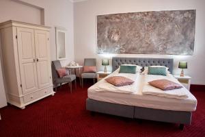 a bedroom with a bed and a large painting on the wall at Charma Residence in Sibiu