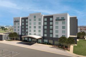 a large white building with a canopy next to a street at Embassy Suites by Hilton Dulles North Loudoun in Ashburn
