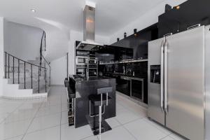 a kitchen with stainless steel appliances and black cabinets at Diamond Villa in Gennadi +25 photos