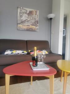 a table with a bottle of champagne and two wine glasses at CENTRE-CATHEDRALE-CORDELIERS avec garage in Reims
