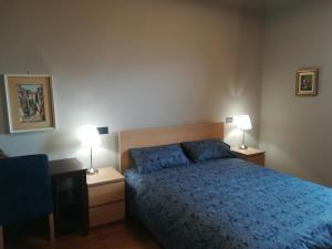 トリエステにあるB&B Ferlugaのベッドルーム1室(青いベッド1台、ランプ2つ付)