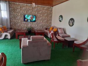 uma sala de estar com sofás e um tapete verde em VICTORIA RIPPLE HOTEL { WINAM } em Kisumu