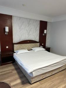 a bedroom with a large bed with white sheets at G Empire in Astana