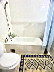 a bathroom with a toilet and a bath tub and a toilet at 224 Чудесный вид на Байтерек с 2 диванами и большой кроватью для 1-5 чел in Astana