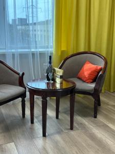 two chairs and a table with a wine glass on it at G Empire in Astana