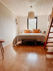 ein Schlafzimmer mit einem Bett und einem großen Fenster in der Unterkunft Luxurious red cottage with wood stove near lake in Nye