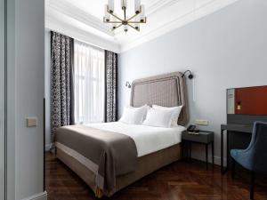 a hotel room with a bed and a window at Helvetia Hotel in Saint Petersburg