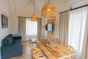 a living room with a wooden table and chairs at La Galeria - Hotel Boutique Cariló in Carilo