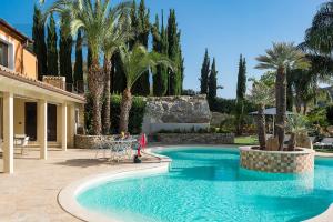 una piscina en un patio con palmeras en Agorà, en Agrigento