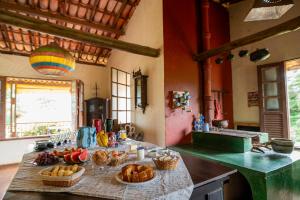 a kitchen with a table with baskets of food on it at Pousada Namaste in Casa Branca