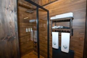 a bathroom with wooden walls and a shower with towels at Bİ ABANT MASALI VİLLAGE HOTEL in Arkaoğluköyü