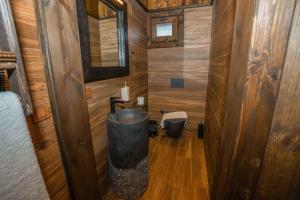 La salle de bains est pourvue de murs en bois et de parquet. dans l'établissement Bİ ABANT MASALI VİLLAGE HOTEL, à Arkaoğluköyü