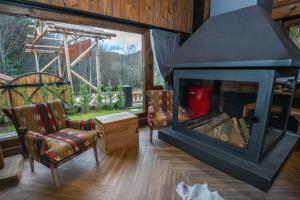 a living room with a fireplace and a chair at Bİ ABANT MASALI VİLLAGE HOTEL in Arkaoğluköyü